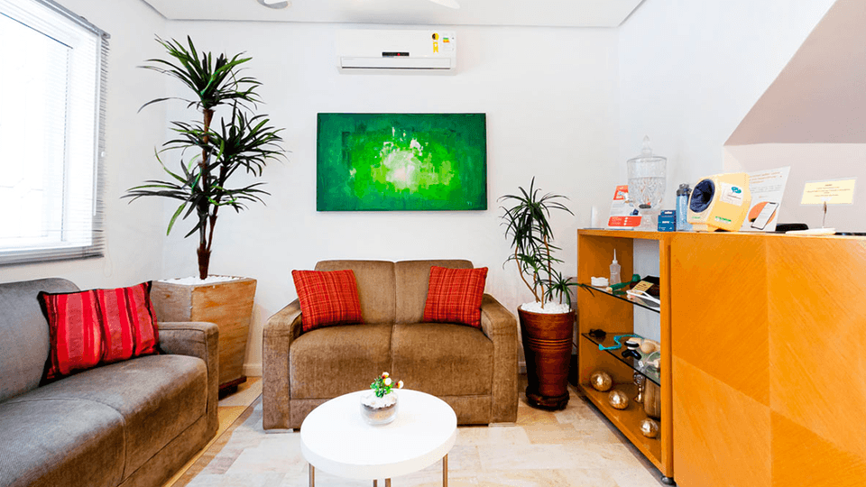 Sala de espera com sofás e ambientação acolhedora